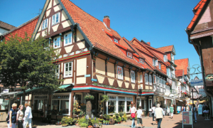 Celle_Piltzergasse-Fachwerk Fachwerkhaus mit rotem Dach und Außengastronomie in belebter Altstadt von Celle.