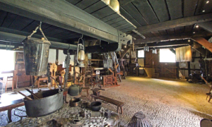 Celle_Winsen_Mueseumshof_Zweista__nderhaus_Halle Historischer Werkraum mit alten Geräten, Werkzeugen und Holzbalken.